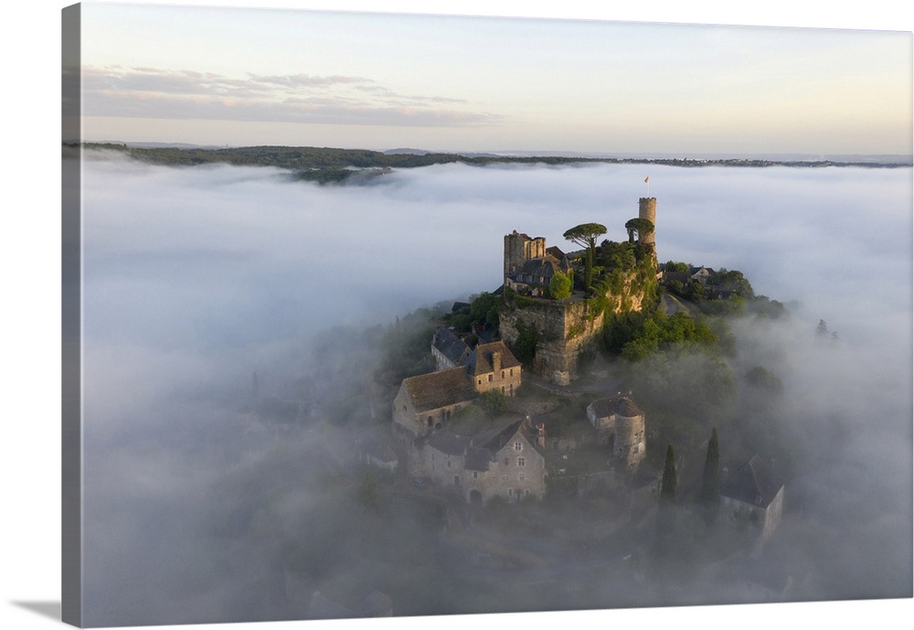 An aerial view of the hilltop village of Turenne at sunrise surrounded by mist, Correze, Limousin, Nouvelle-Aquitaine, Fra...