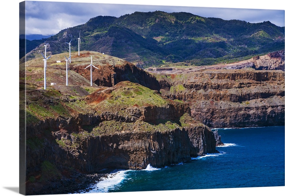 Windmills generating electrical energy located on the cliffs of Ponta de Sao Lourencol with the Atlantic Ocean below at Po...