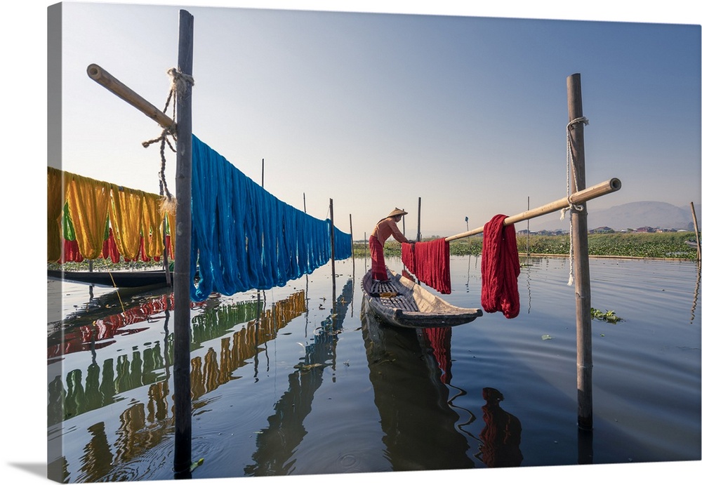 Woman hanging dyed yarn from a boat to dry in a traditional weaving village on Lake Inle, Nyaungshwe Township, Taunggyi Di...