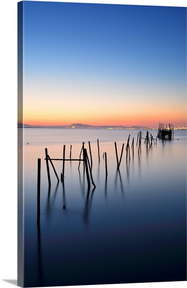 Wooden pillars piers, a palafite fishing harbour of Carrasqueira at dusk. Alentejo, Portugal.