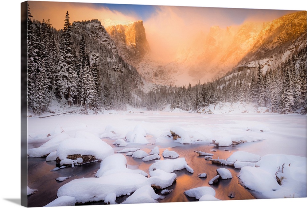 Giant photograph of a snow covered landscape filled with trees surrounding and a frozen river running down the center of t...
