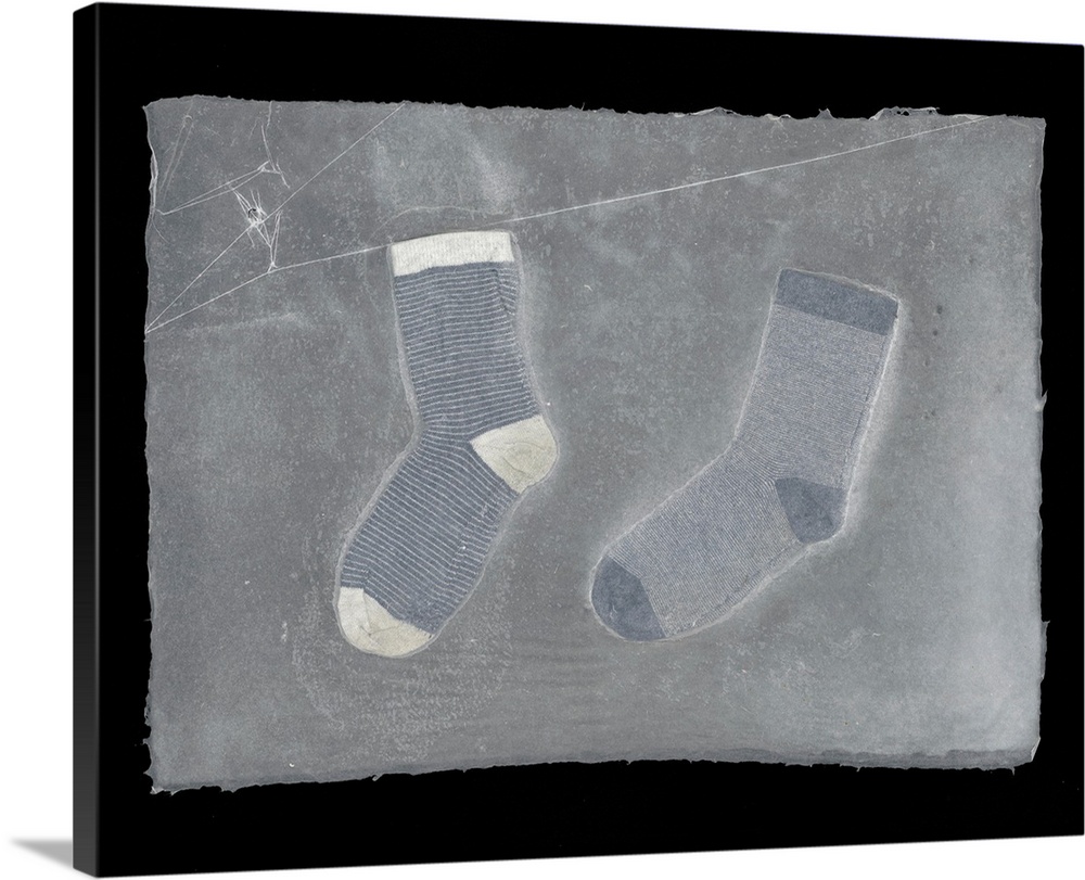 Two striped children's socks suspended in handmade paper.