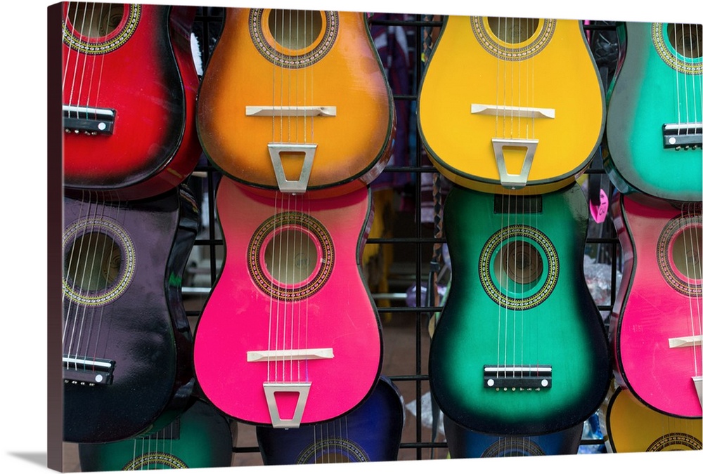 A photo of acoustic guitars on a wall.