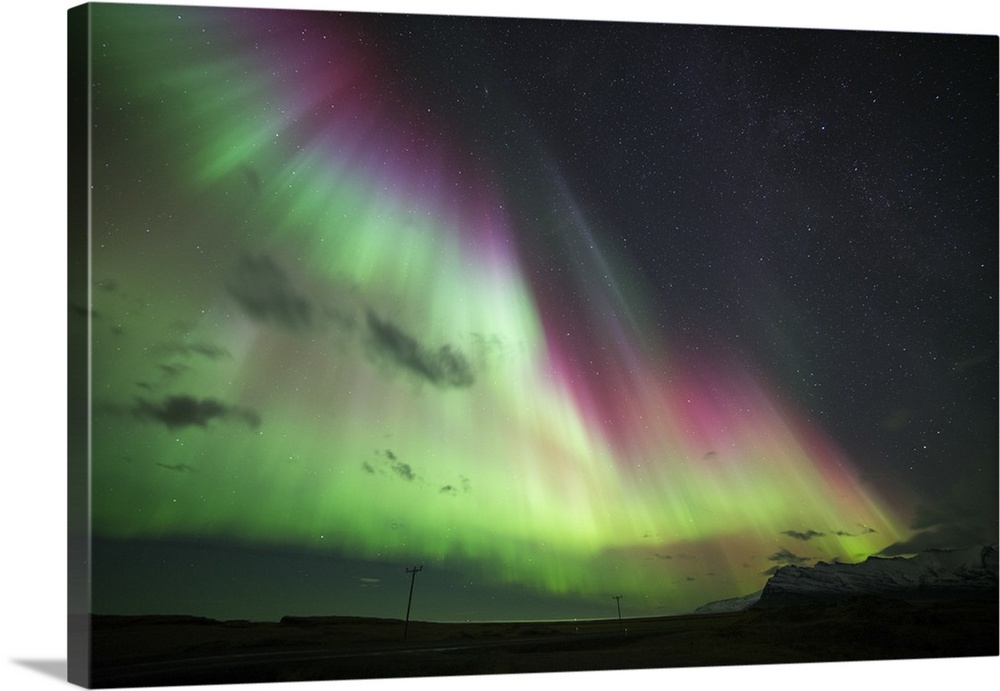 Photograph of the Aurora Borealis illuminated in a starry night sky.