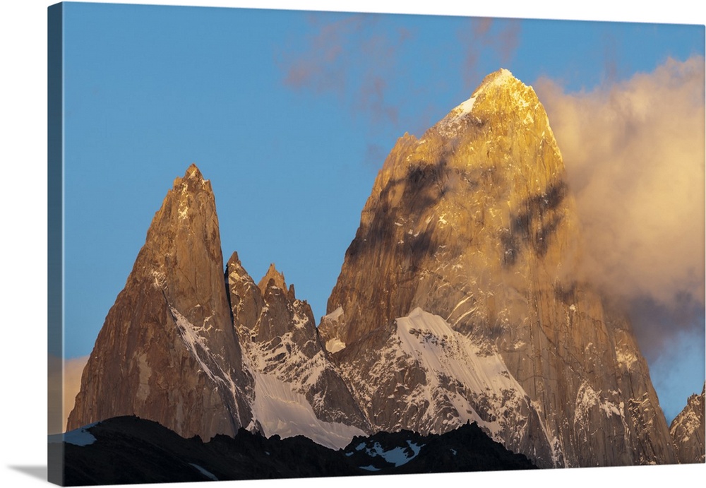Photograph of mountain spires in South America, with clouds moving in to the frame of the image.