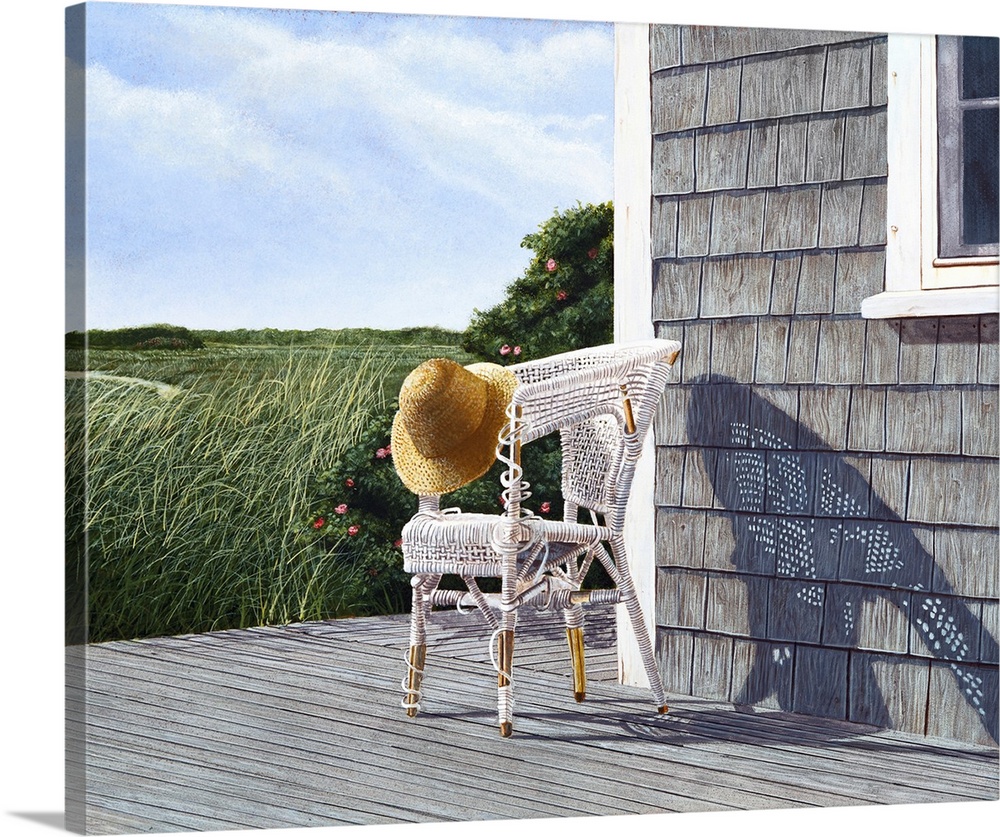 Whicker chair and straw hat on a deck.