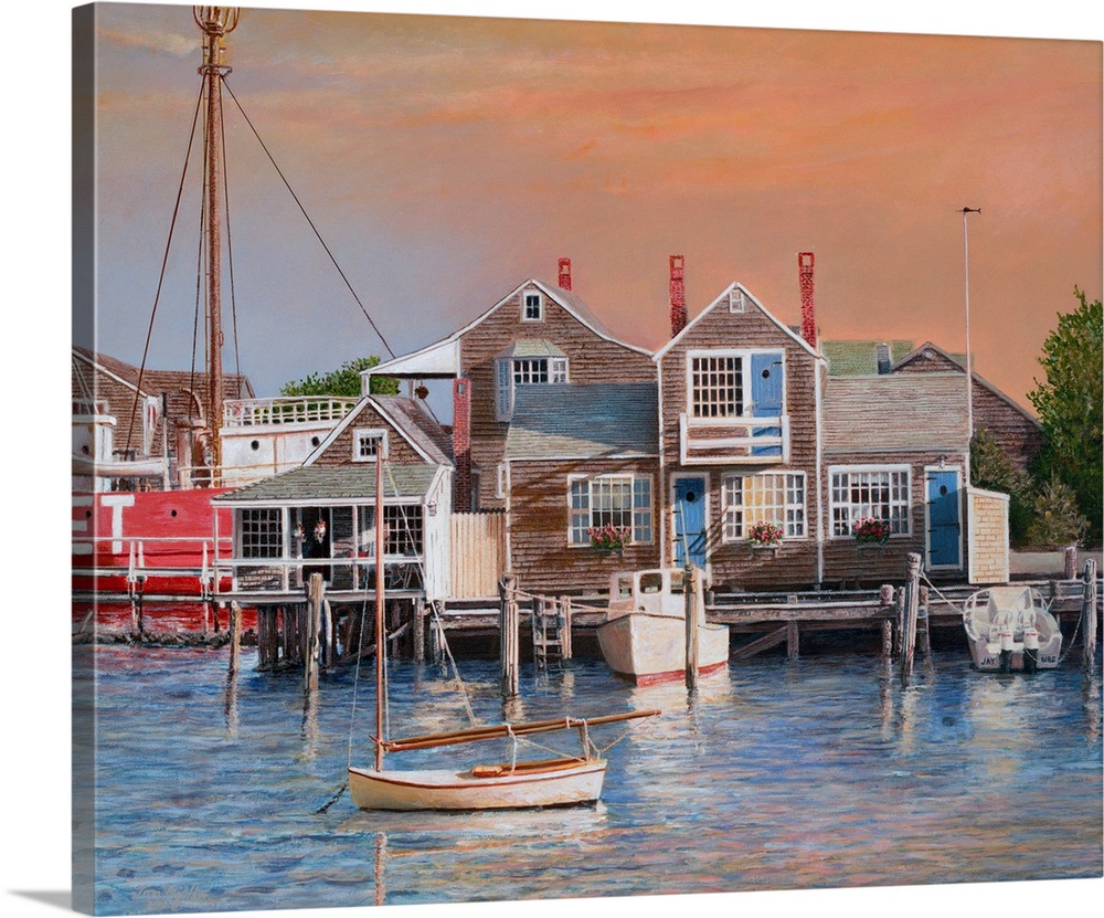 Houses on harbor wharf with dock and moored boats at sunrise.