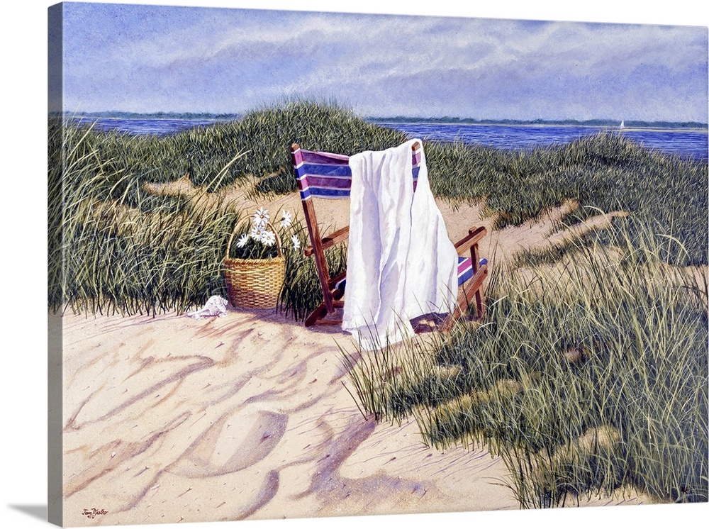 Basket of white flowers next to a striped beach chair with a towel in sandy beach and grass with water and sailboat in the...