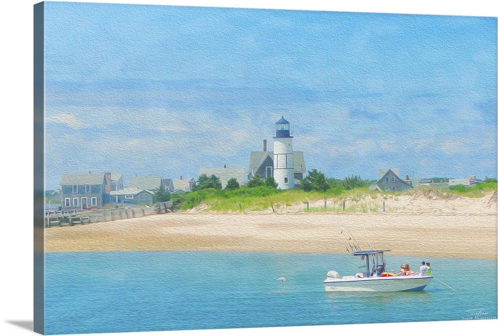 A lighthouse on the beach with a boat on the water in New England.
