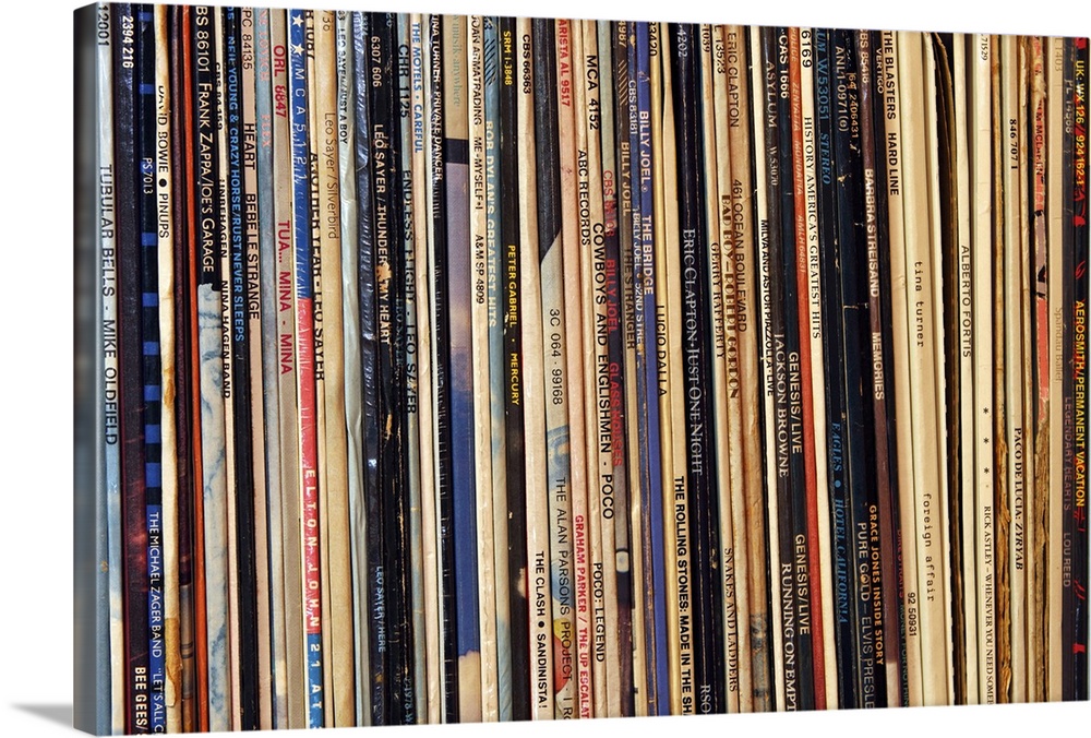 Horizontal, close up photograph of a row of tightly packed records in their sleeves.