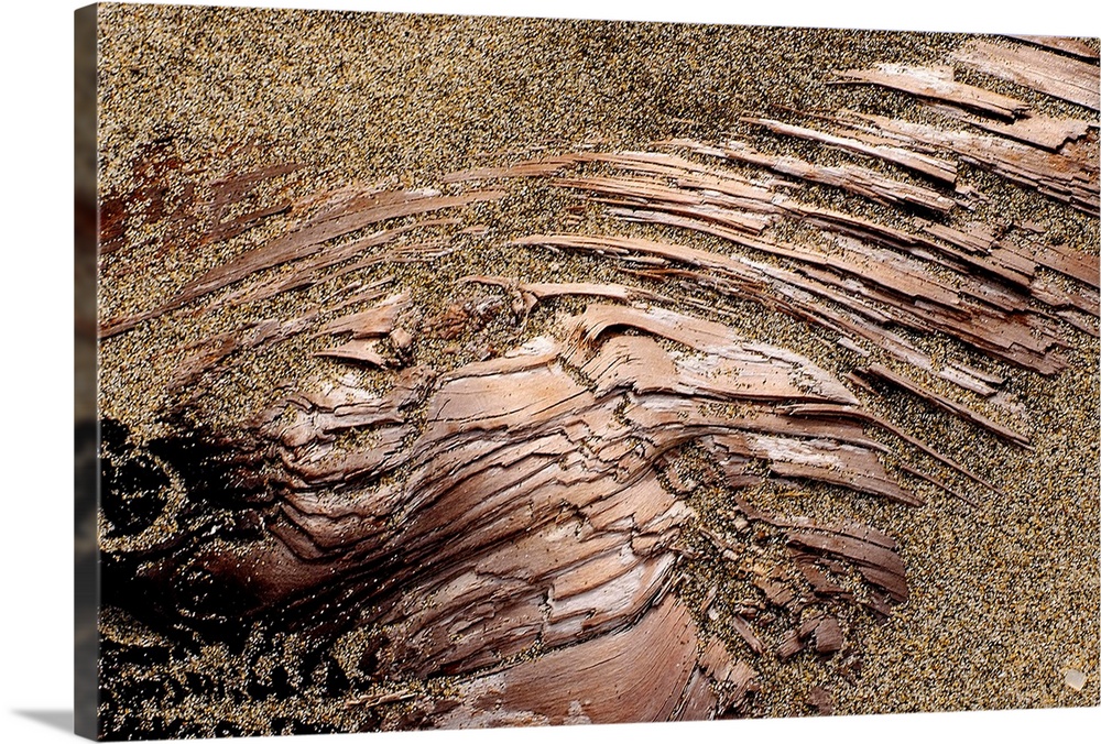 Photograph of dirt covering smooth copper-like rock.