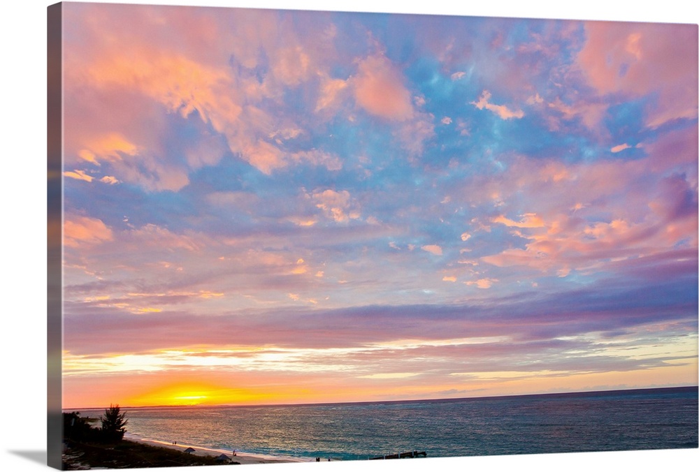A beautiful delicate pink and purple sky at sunset over Grace Bay, and the shore.