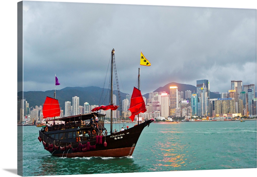 A boat named Aqualuna in Victoria Harbor with the Hong Kong skyline in the distance.