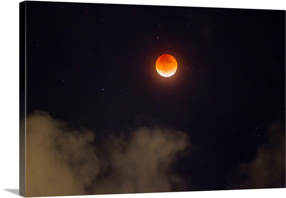 A break in the clouds reveals a rare lunar eclipse, also known as the super moon, or blood moon.