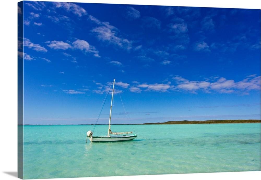 A lone sailboat anchored in turquoise water.
