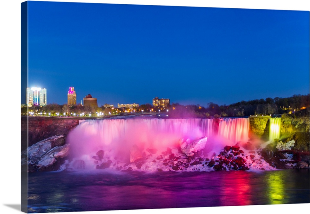 American Falls illuminated at dusk by colorful lights.