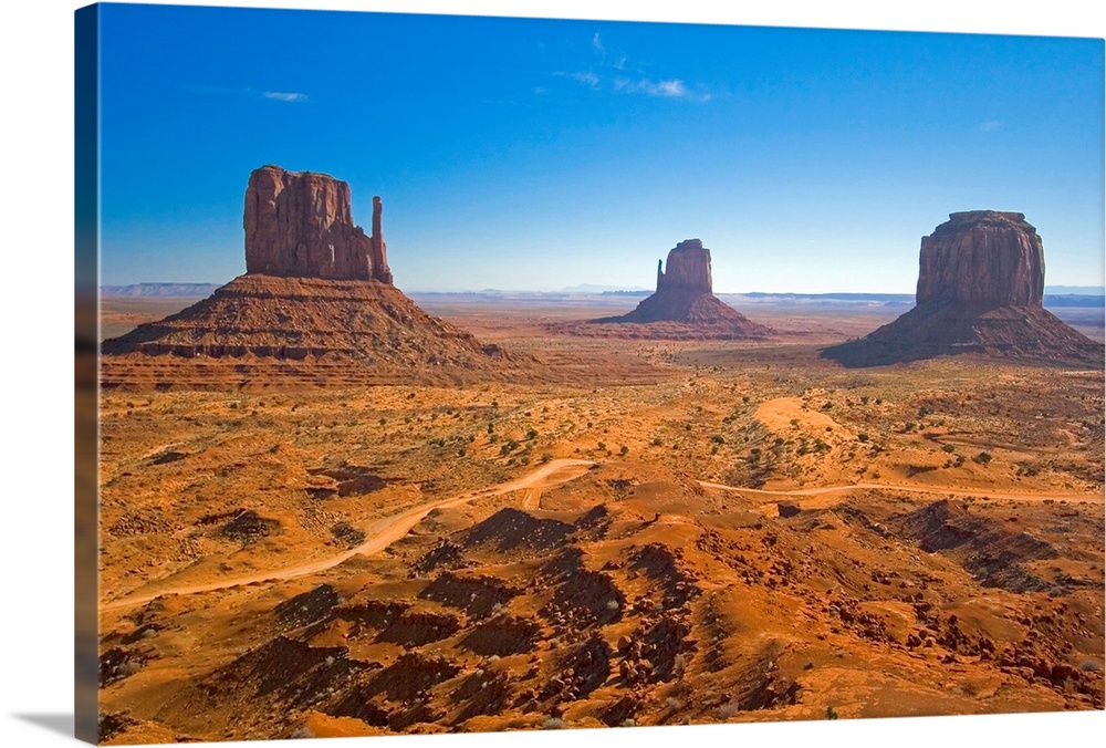 Horizontal photograph from the National Geographic Collection of the vast, sandy landscape of Monument Valley, including t...