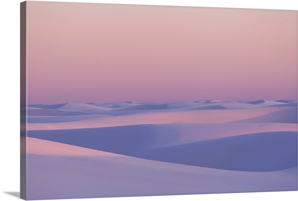 Pink and purple illuminated sand dunes during sunset.