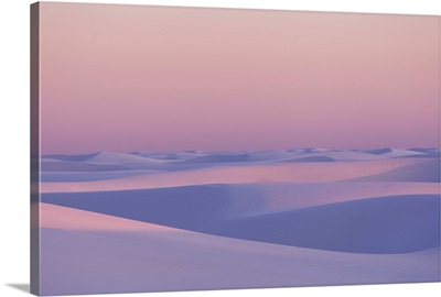 Pink and purple illuminated sand dunes during sunset