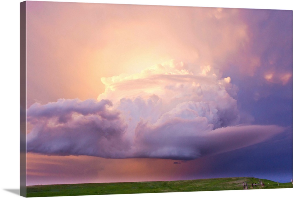 Sunset paints a decaying thunderstorm and the sky a glowing purple and pink.