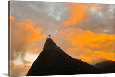 The Christo Redentor statue before an intense orange glow at sunset
