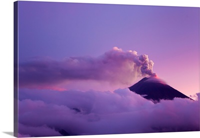 The cloud-shrouded Tungurahua volcano erupting at twilight
