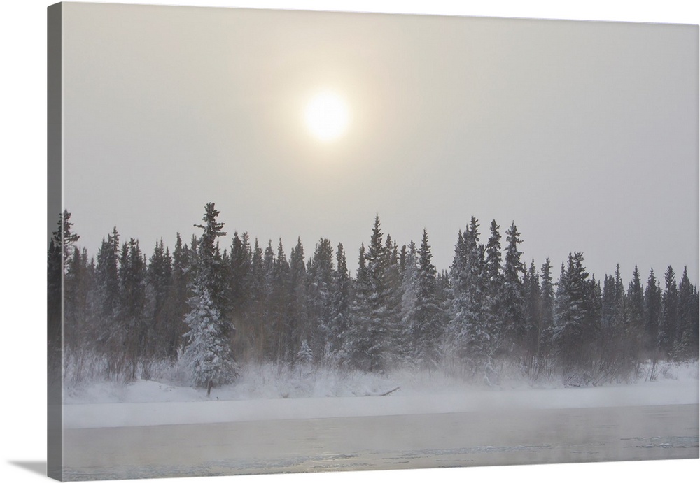 The sun glowing through thick clouds in subzero temperatures along the Yukon River.