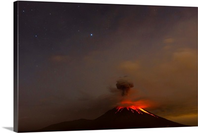 The Tungurahua volcano erupting at night under a starry sky
