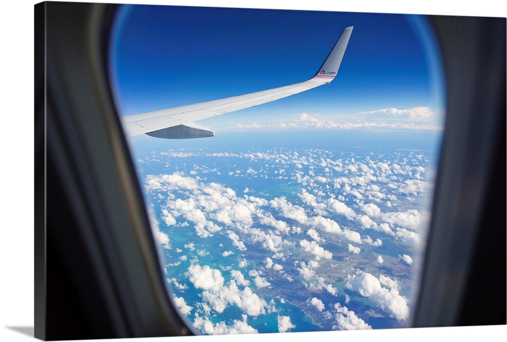 View through a passenger airplane window flying over the Caribbean.