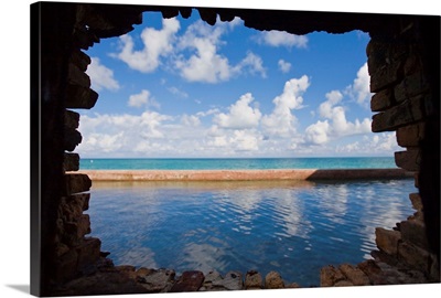 Water and clouds seen through a hole in a brick wall at Fort Jefferson