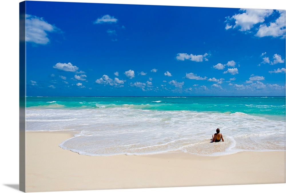 Woman enjoys a perfect beach day of clear skies and blue waters.