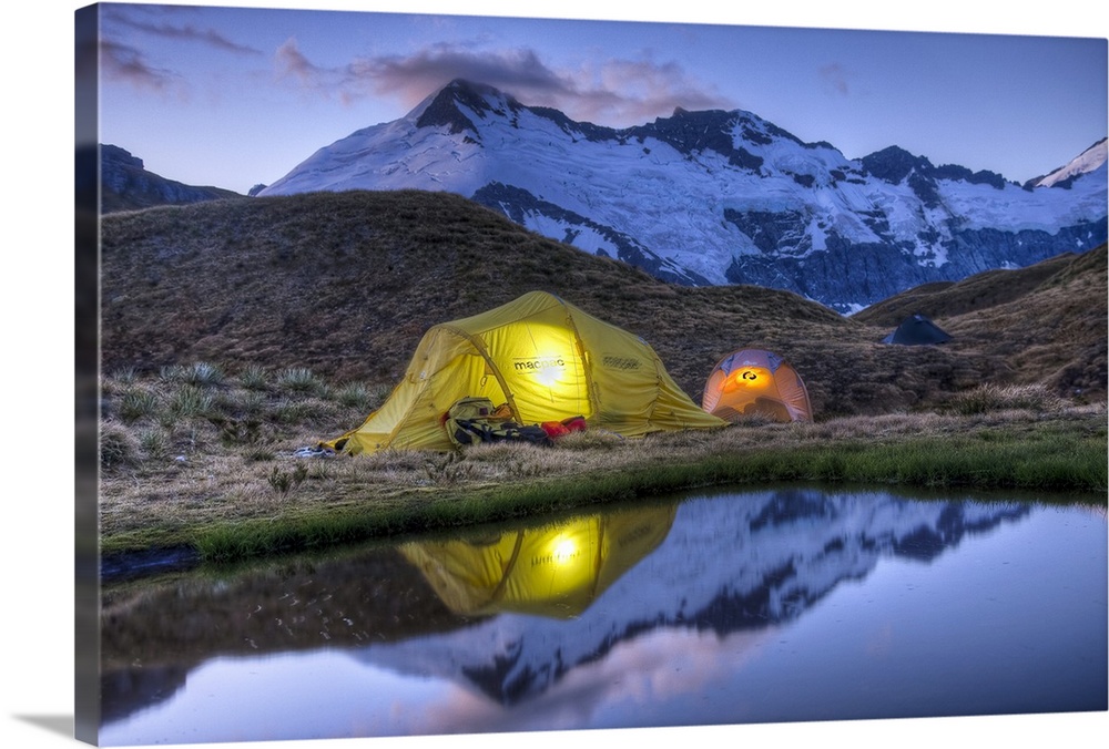 Campers read in tents lit by flashlight, Cascade Saddle, Mount Aspiring National Park, New Zealand
