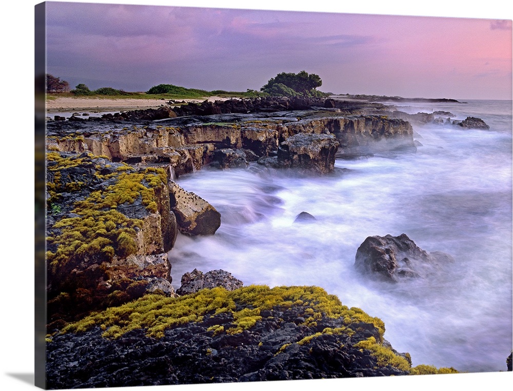 Photograph of rocky cliff line that drops into the ocean under a cloudy sky.