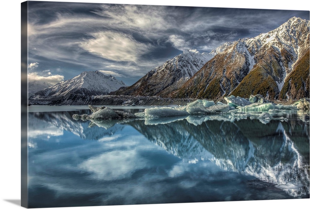 Mirror image, reflection of clouds, peaks and icebergs in Tasman Glacier Lake, Mount Cook National Park, New Zealand