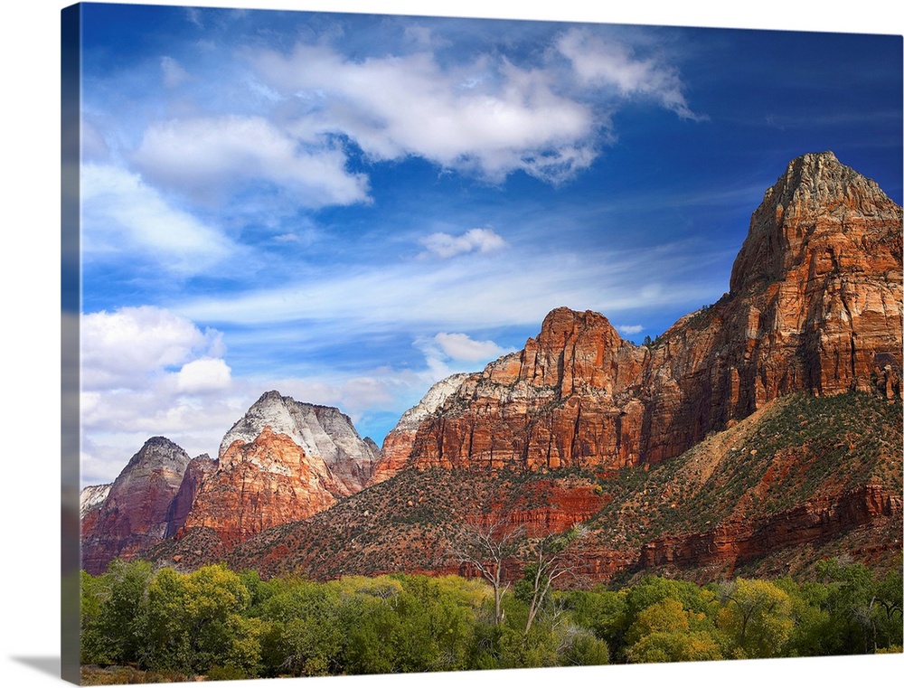 Large photograph of canyon mountains and desert underbrush growth on a sunny day.