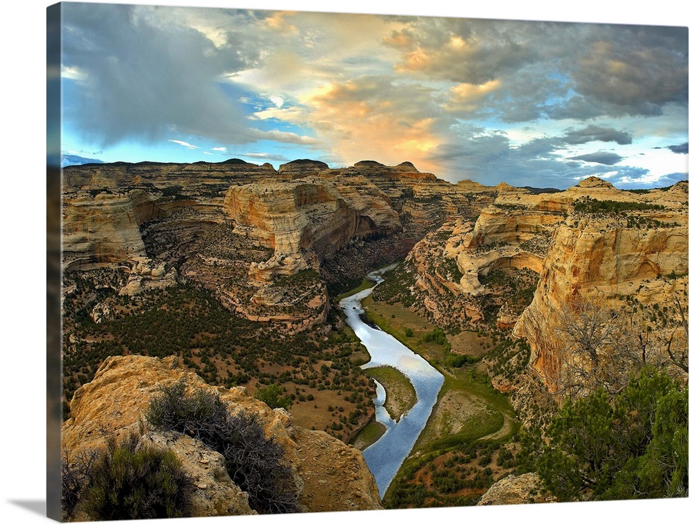 High angle photograph of river flowing through canyon under a cloudy sky.