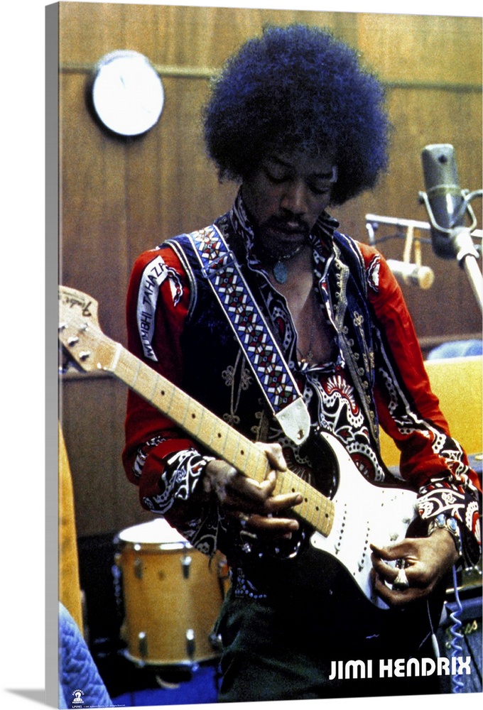Vintage color photograph of the musician Jimi Hendrix strumming an electric guitar and wearing a brightly decorated and em...