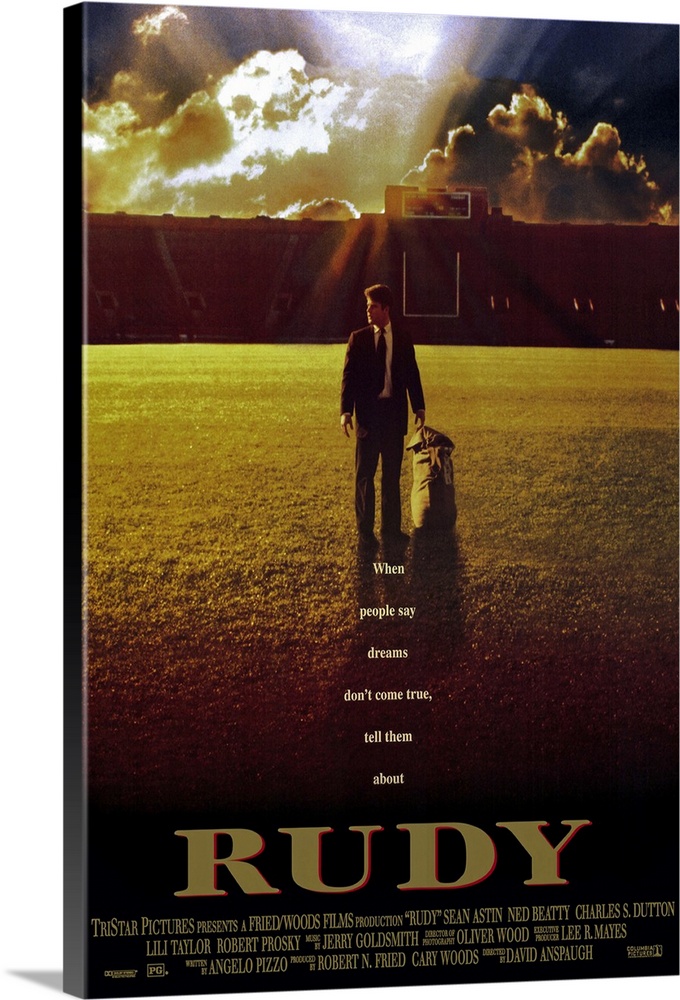 This large vertical piece is a movie poster for "Rudy". It pictures the star character walking across the football field i...
