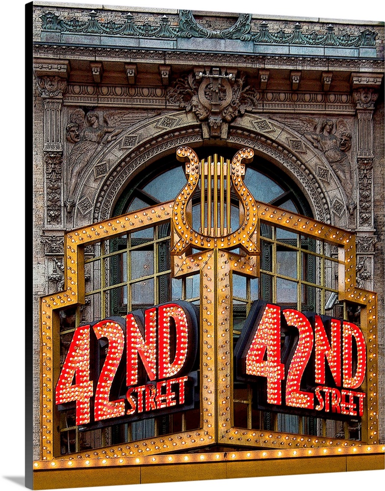 Vibrant photograph of a lit up 42nd street sign on the facade of a building.