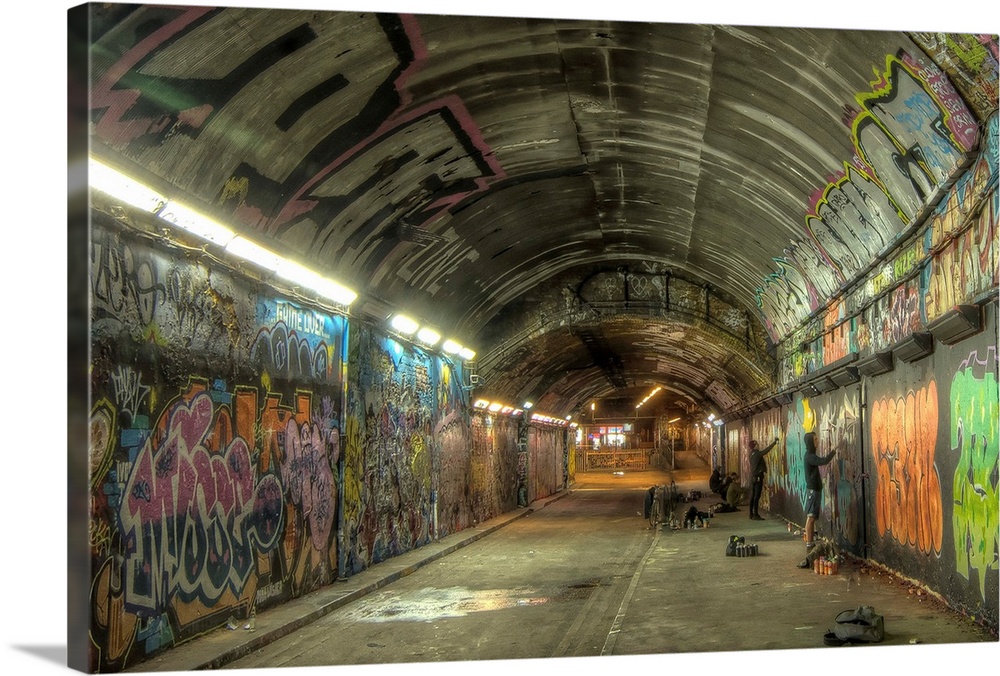HDR photograph of a tunnel with its walls filled with graffiti.