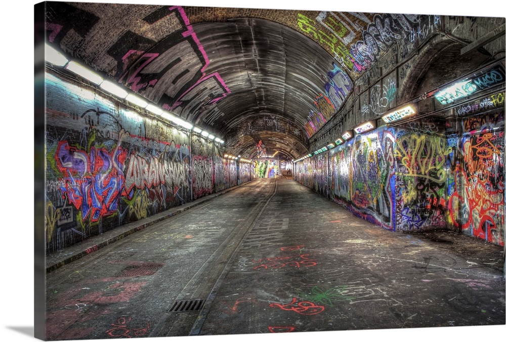 HDR photograph of city tunnel walls covered in graffiti.