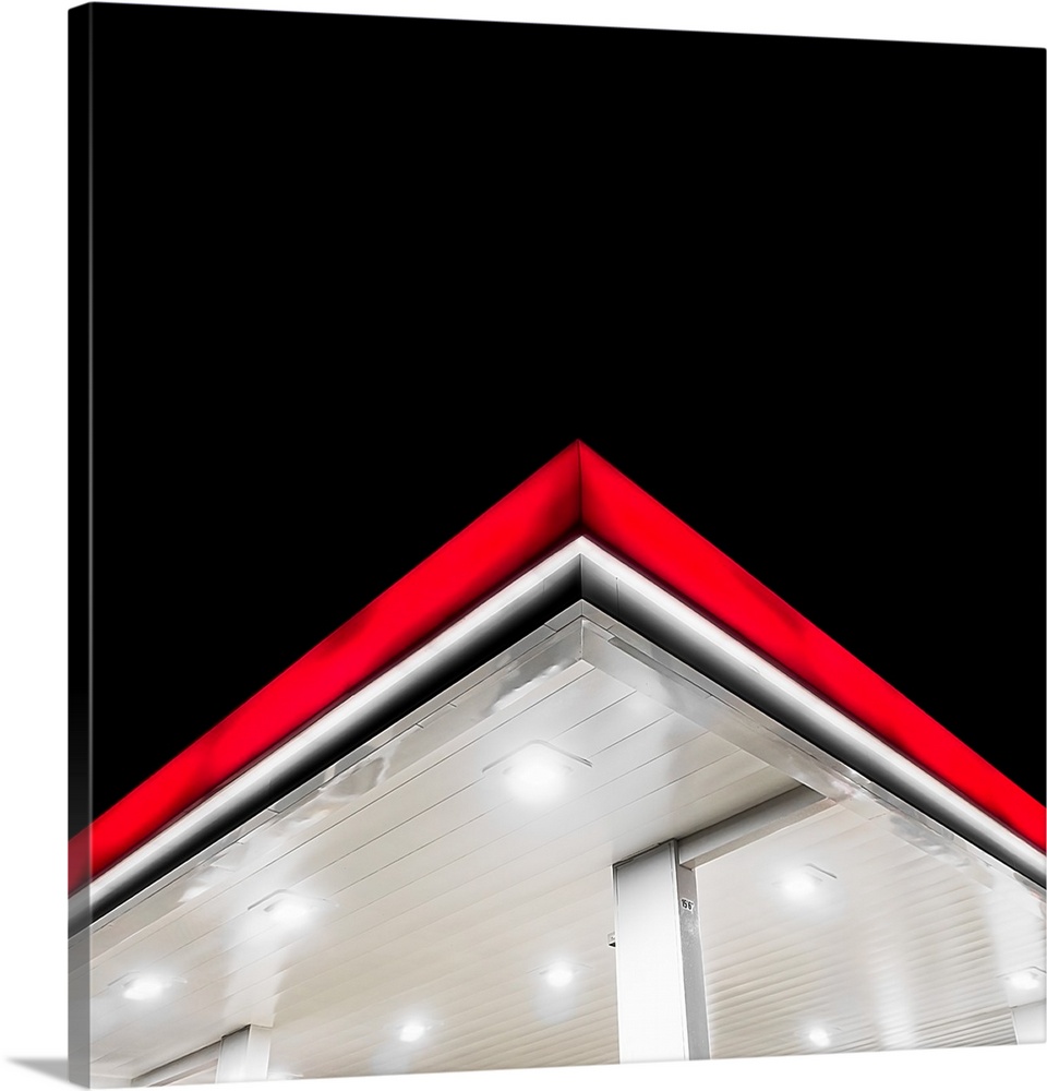The bright red edge of a gas station overhang at night.