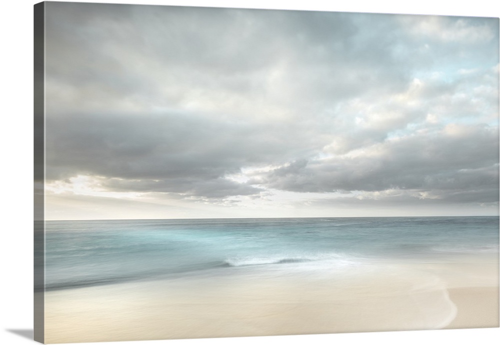 Romantic deserted beach with teal water and soft clouds.