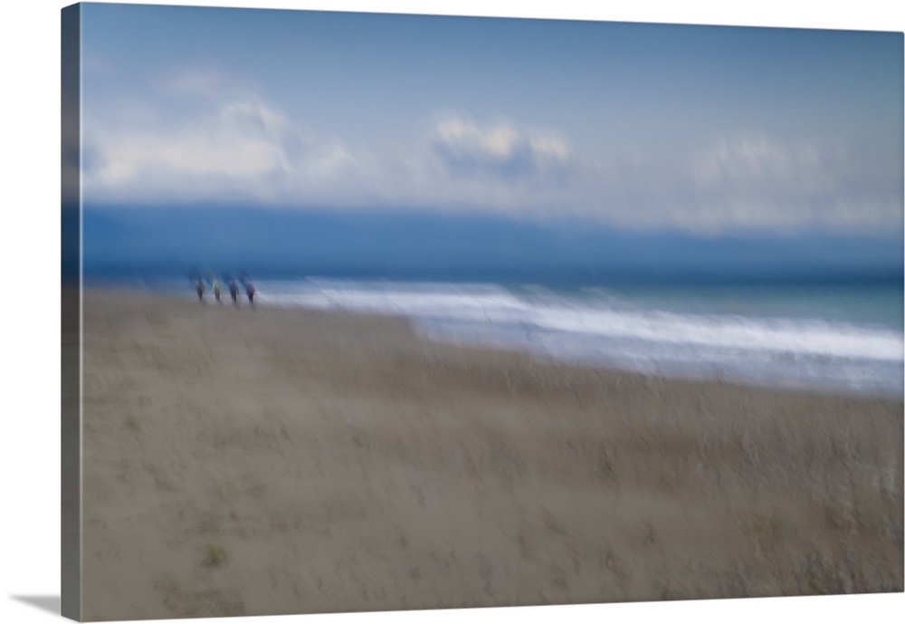 Blurred motion image of a couple walking along the shore.