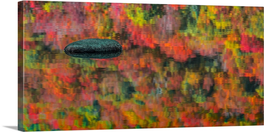 Bright colors of autumn leaves reflected in the waters of a lake.