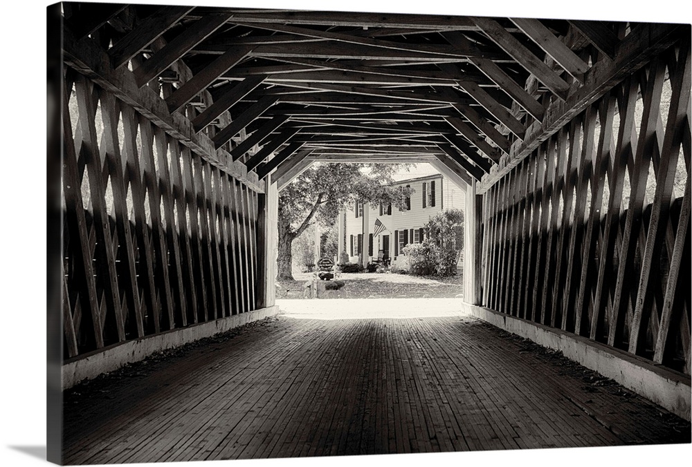 Fine art photo of the inside of a wooden covered bridge, in black and white.