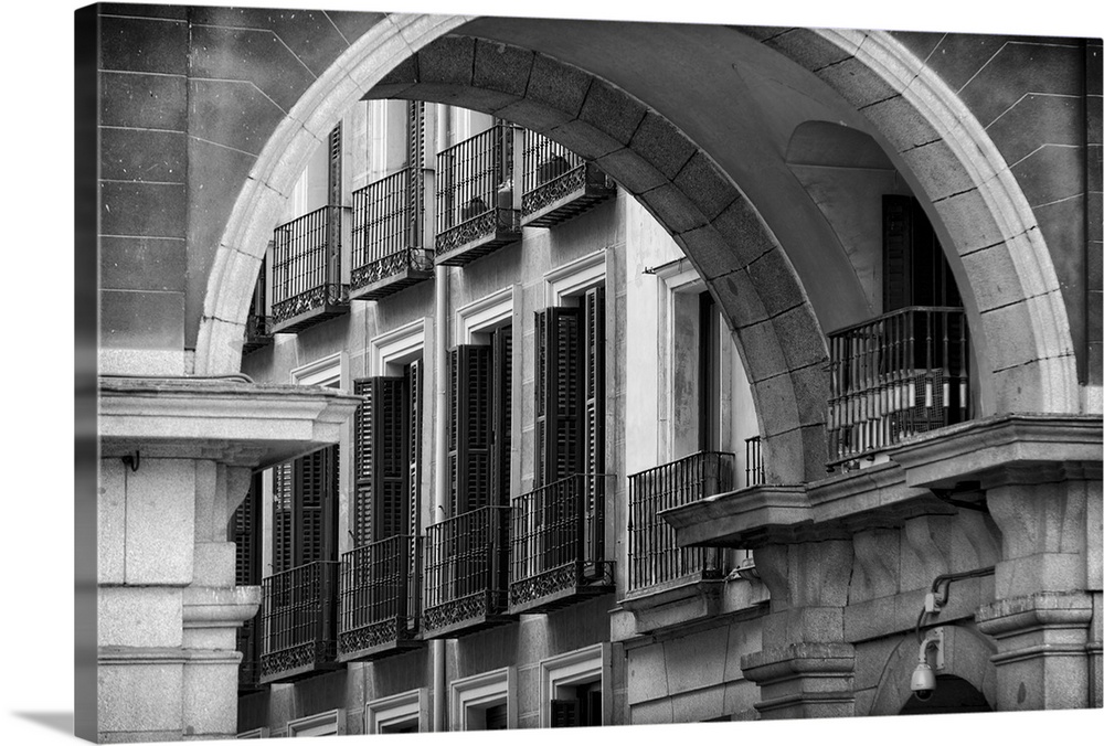 Balconies and Windows with Shutters Viewed through an Arch of Spain