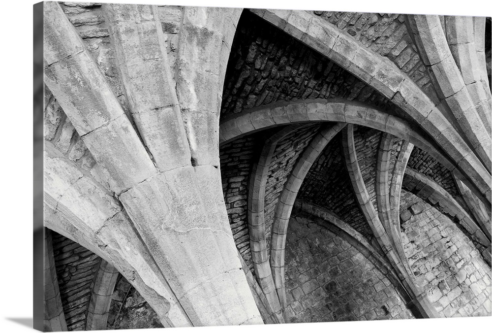 A receeding passage through gothic arches in monochrome black and white.