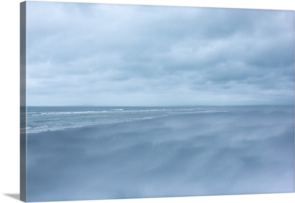 Dense clouds over the ocean before a storm, in pale blue light.