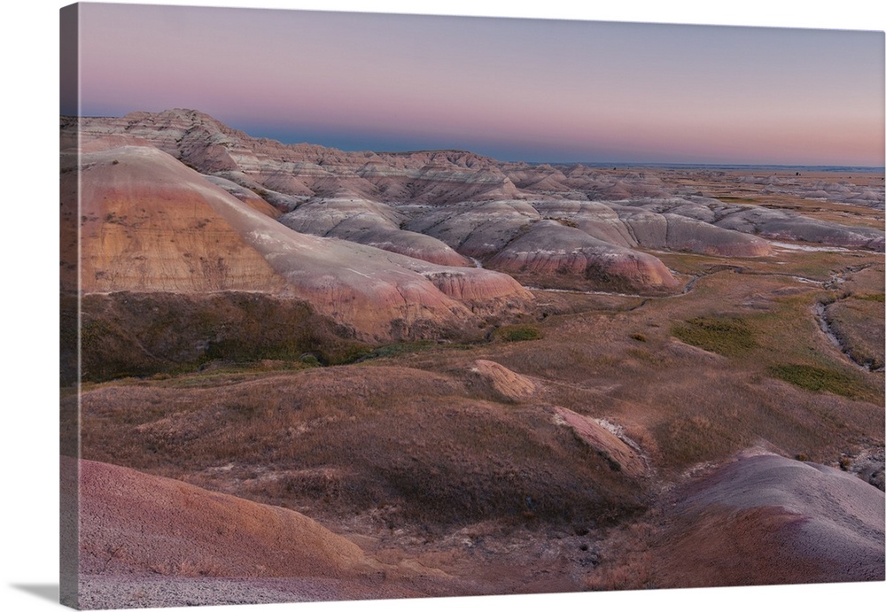 Sunset over layered rock formation in Badlands National Park, South Dakota.